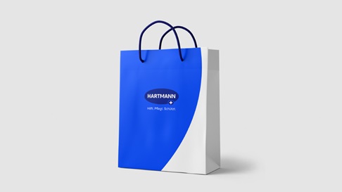 A paper bag with HARTMANN logo and slogan.