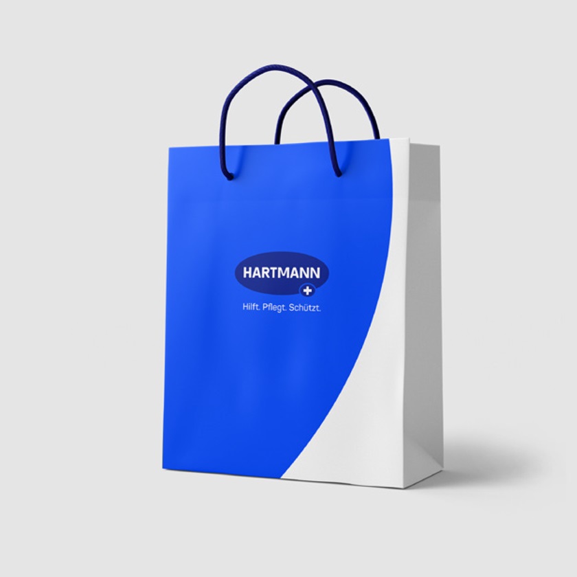 A paper bag with HARTMANN logo and slogan.